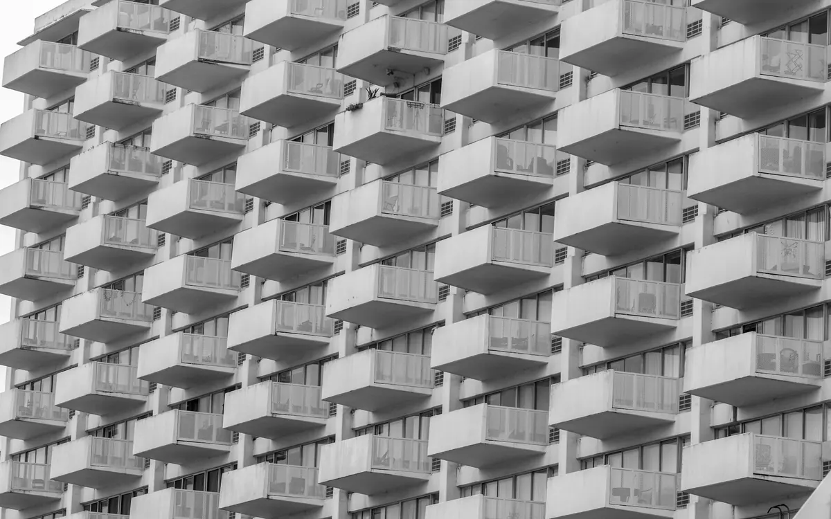 Beyaz cepheli bir apartmanın sıra sıra balkonları